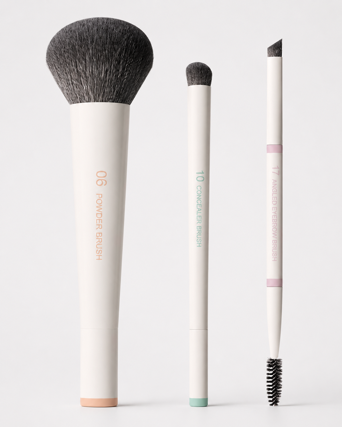 Three cream Mini PRO brushes standing in a row: powder, concealer and dual-ended angled eye